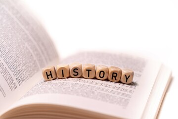 the word HISTORY spelled on an open book with wooden letters, concept picture with white background