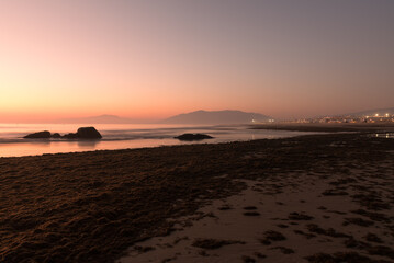 Long exposure view of Los Lances beach in the town of Tarifa on the Andalusian coast in a foggy sunset, Cadiz, Andalusia, Spain