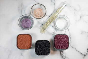 Variations of salts, red, lava, purple, pink; Himalayan and sea salts on a marble counter top background