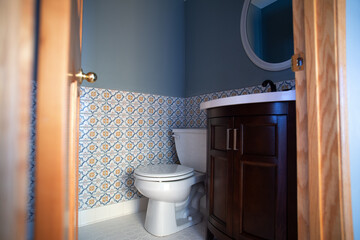 Fototapeta na wymiar A tiled bathroom view, including a toilet and a vanity.