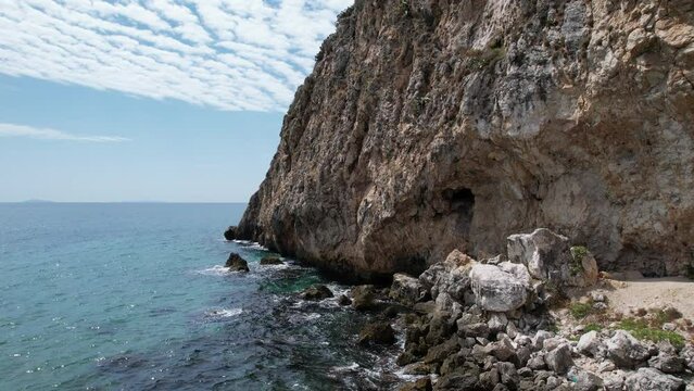 Drohne Luftaufnahme Monte Circeo - T&uuml;rkis Smaragdgr&uuml;n Kristallklares Wasser mit Nahaufnahme auf die Brechende Wellen am Ufer und K&uuml;ste. Sonniger Sommertag am Meer und Flauschiger Wolken. Italien