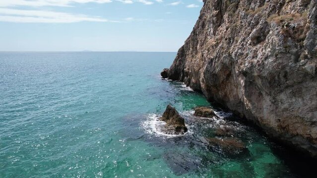 Fliegen &uuml;ber dem Meer. Drohne Luftaufnahme felsiger Italien K&uuml;ste. Filmlandschaft des Ozean.  T&uuml;rkis Smaragd Kristallwasser mit ruhigen Wellen und Sonnenstrahlen. Sonniger Sommertag am Meer.