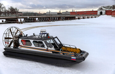 Amphibious boat of the search and rescue service of St. Petersburg on the river ice against the background of the Peter and Paul Fortress.
