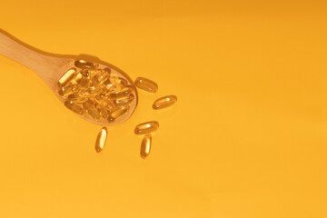 omega 3 from a spoon on yellow background