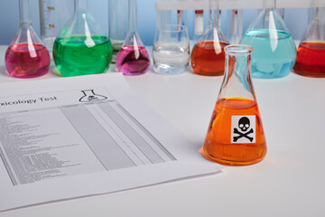 Toxic report for orange juice and colored chemical flasks. Toxicology analysis for food safety of orange drink. Food control of colored fluids. Paper report page of poison component analysis. - obrazy, fototapety, plakaty