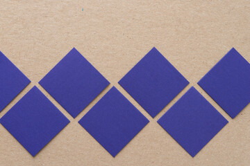 Fototapeta premium blue paper squares on a cardboard background