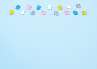 composition of multi-colored wooden small rabbits on a blue background. Easter concept. copy space.