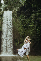 Fototapeta na wymiar photo session of a couple in love, wedding photo session, young couple, photo of a couple at the waterfall, couple near the waterfall
