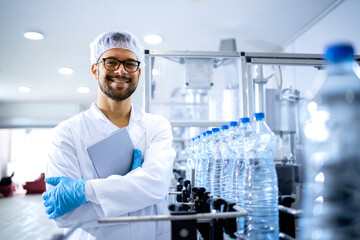 Portrait of an experienced caucasian technologist working in bottling factory producing drinking...