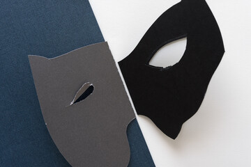 two folded paper masks on blue and white paper