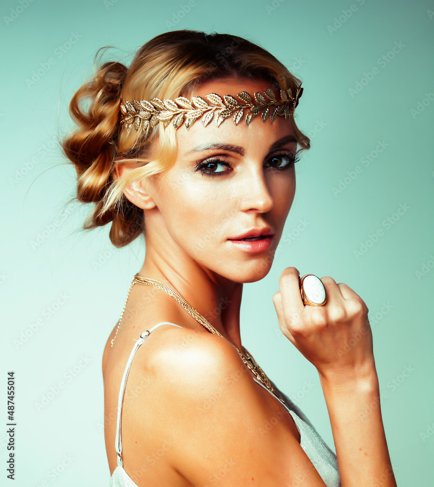 Wall mural young blond woman dressed like ancient greek godess, gold jewelry close up isolated, beautiful girl hands manicured red nails