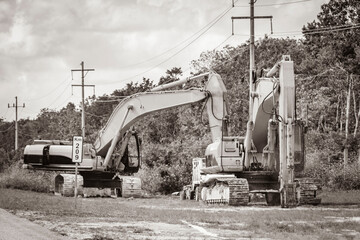 Fototapeta na wymiar Excavators and other industrial vehicles destroy the jungle Tulum Mexico.
