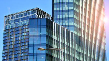 Obraz premium Fragments of building in business district of modern city. High-rise office building in downtown. Modern architecture of typical concrete, glass and steel.
