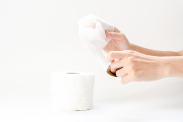 Hand and toilet paper on white background.