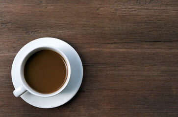 Coffee in white cup on the wooden table.