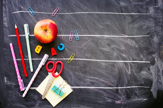 back to school background with black chalk board and school suppilents