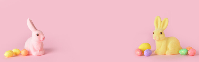 Easter bunnies and eggs on pink background with space for text