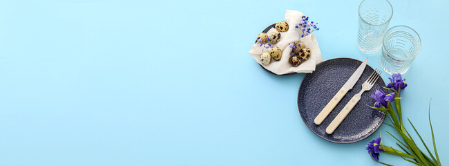 Beautiful table setting for Easter celebration on blue background with space for text