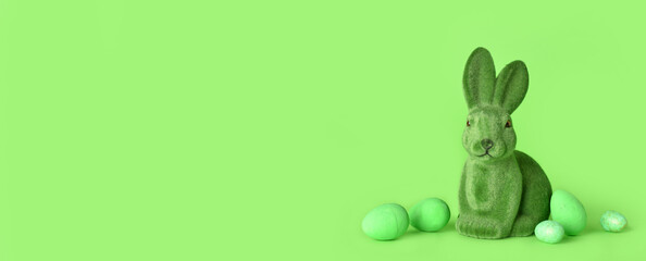 Easter bunny and eggs on green background with space for text
