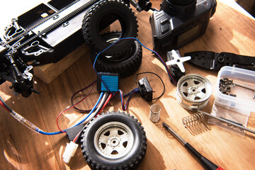 Building motorized scale model cars. Radio control car assembly scene, RC car assembly on wooden...