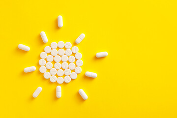 Sun made of pills on yellow background - obrazy, fototapety, plakaty