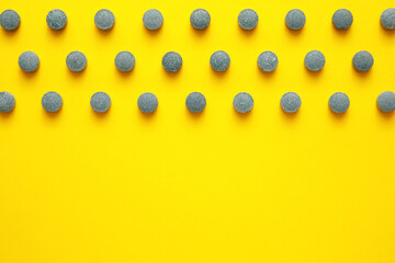 Many pills on yellow background