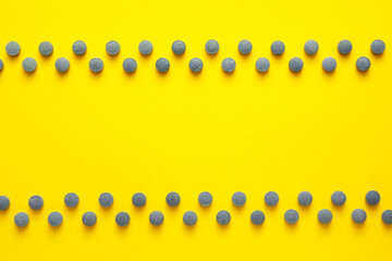 Many pills on yellow background