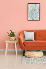 Stylish orange sofa with houseplant in modern interior of living room