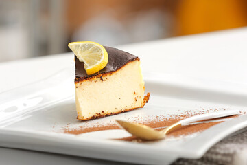Plate with slice of tasty Basque burnt cheesecake on table, closeup