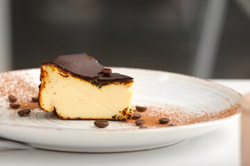 Plate with slice of tasty Basque burnt cheesecake on table, closeup