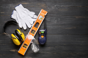 Safety equipment with builder's level and radio transmitter on dark wooden background