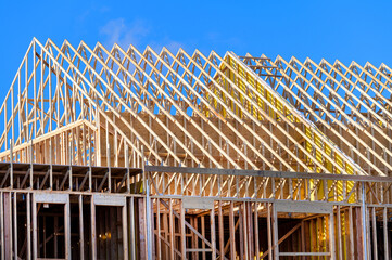 New residential construction home framing against a blue sky roofing construction