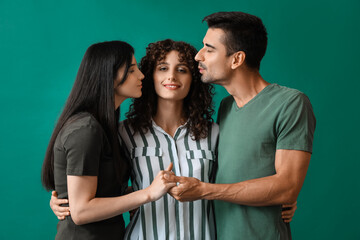 Man and two beautiful women on color background. Polyamory concept