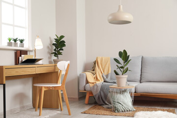 Comfortable workplace with modern laptop in living room interior