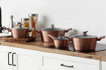 Obraz na płótnie Canvas Shiny copper cooking pots on stove in kitchen