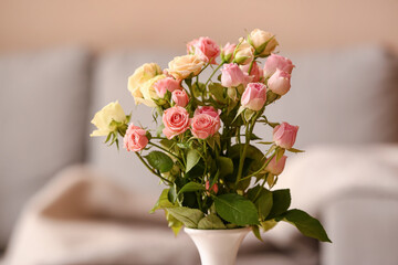 Vase with small beautiful roses in room, closeup