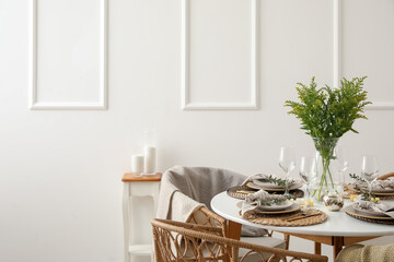 Stylish table setting near white wall