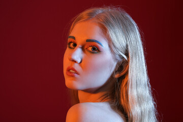 Beautiful girl with unusual eyebrows on color background