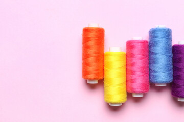 Different sewing threads on pink background