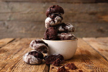 Bowl of chocolate brownie cookies on wooden background