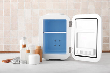 Small refrigerator and cosmetic products on table