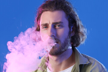 Smoking young man on blue background