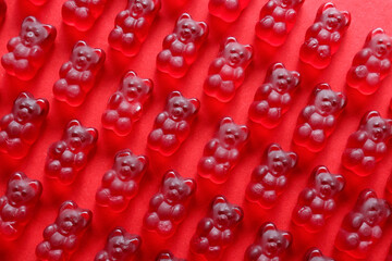 Sweet jelly bears on red background, closeup