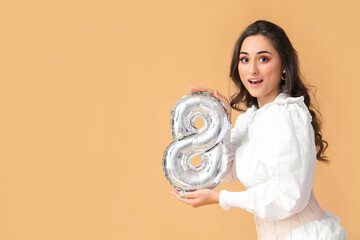 Emotional woman holding balloon in shape of figure 8 on color background. International Women's Day © Pixel-Shot