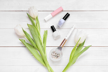 Composition with decorative cosmetics and tulips for International Women's Day celebration on white wooden background