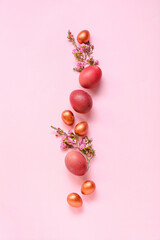 Composition with Easter eggs and flowers on pink background