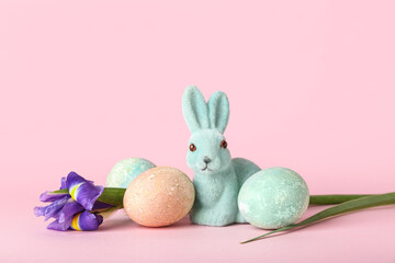 Beautiful Easter bunny, flower and painted eggs on pink background