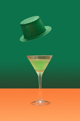 Irish festival minimal concept. Martini glass with green cocktail on terracotta table. Green...