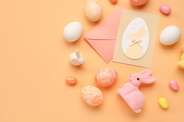 Beautiful Easter composition with greeting card, painted eggs and bunny on color background