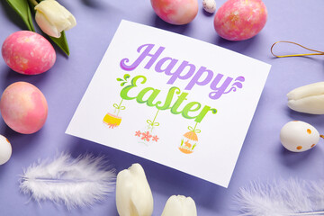 Beautiful Easter composition with greeting card, painted eggs and flowers on purple background, closeup